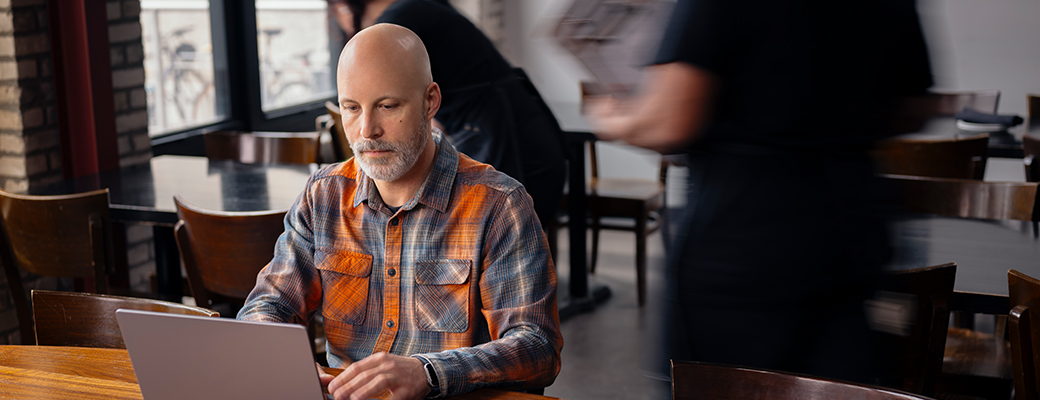 Image of middle-aged man on his laptop in a cafe